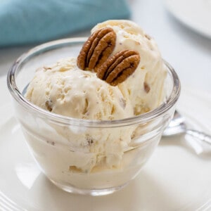 glass bowl of butter pecan ice cream with two pecans