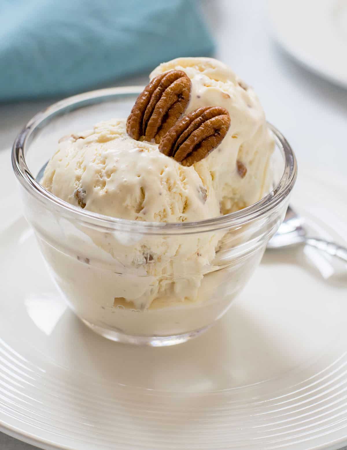 glass bowl of butter pecan ice cream with two pecans