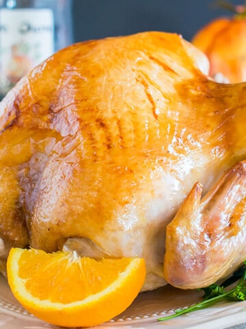 roasted turkey on platter with orange wedge
