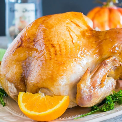 roasted turkey on platter with orange wedge