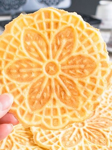 holding pizzelle cookie