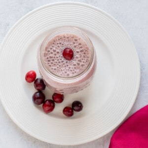 overhead view of cranberry smoothie on plate with cranberries