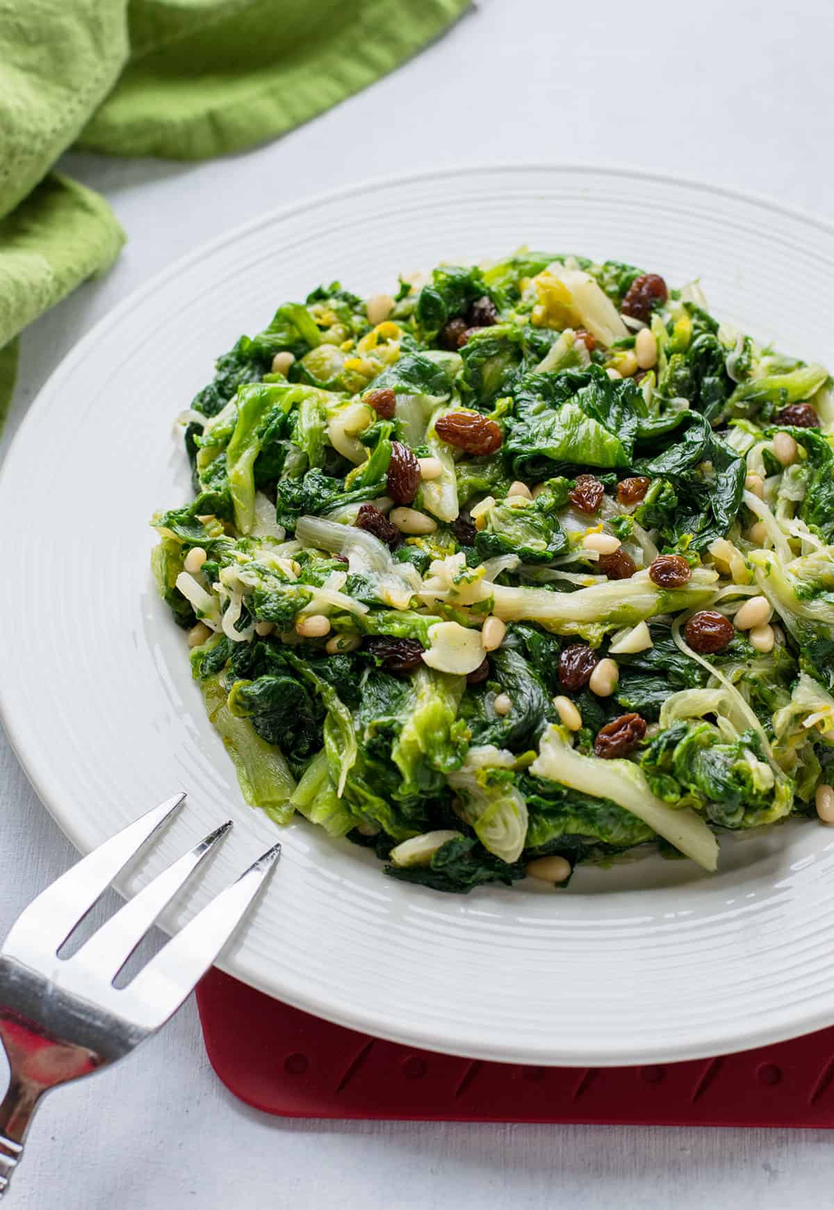 plate of sauteed escarole with garlic, raisins and pine nuts