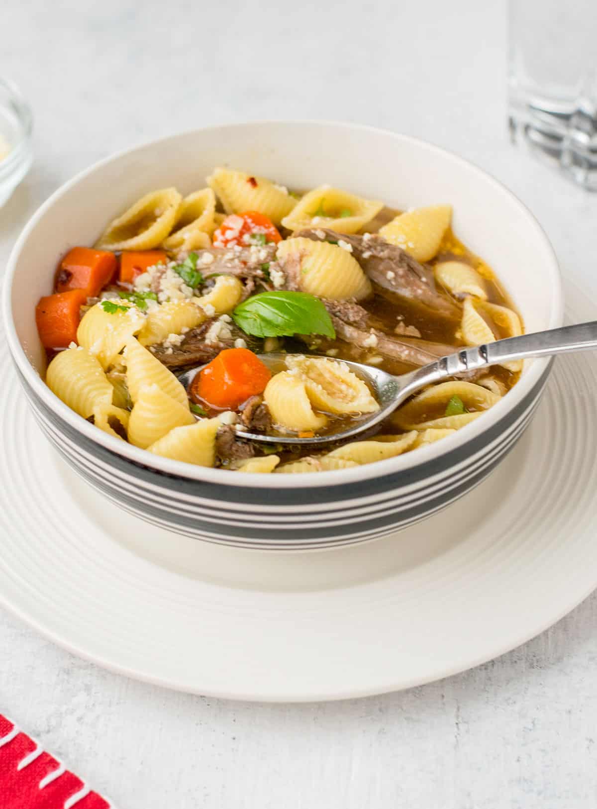 spoonful of soup with beef, carrot and pasta shells