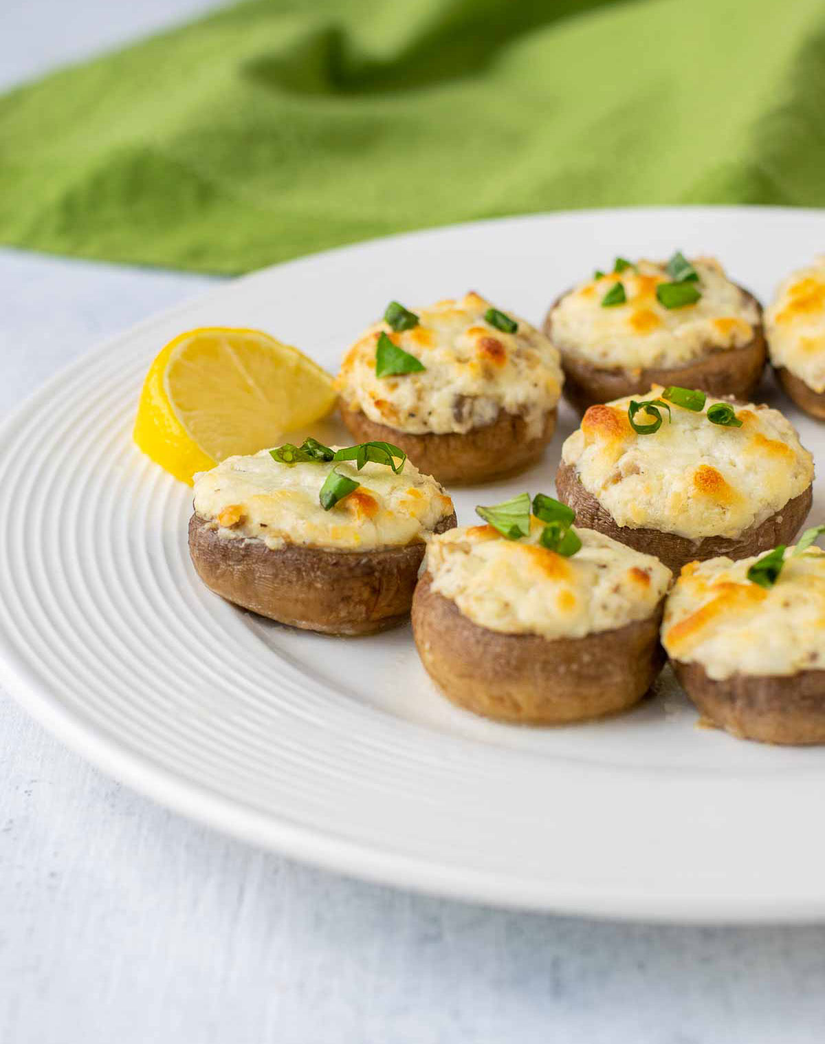 cheese-stuffed mushrooms on plate with lemon and basil ribbons.