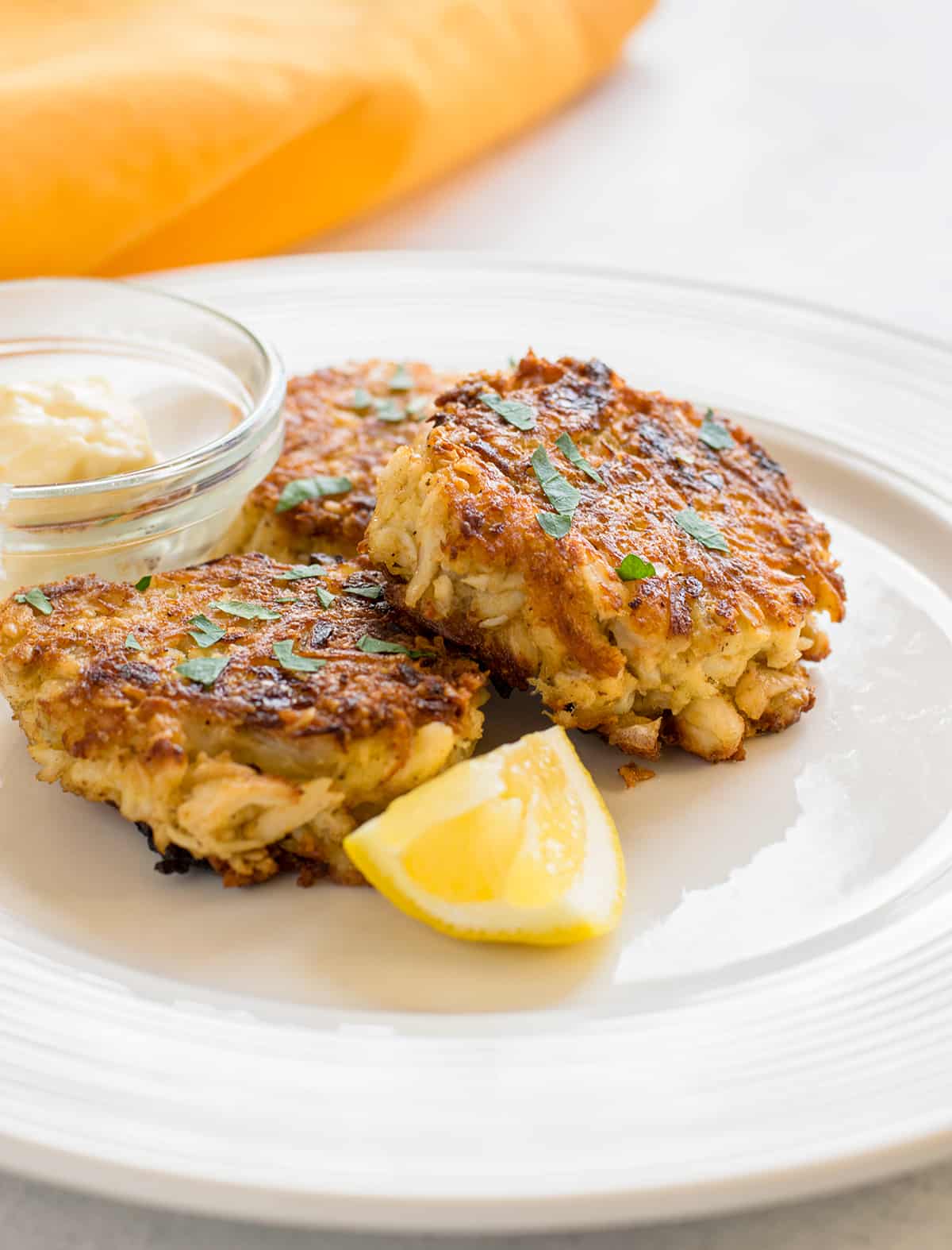 crab cakes with lemon and mayo on plate