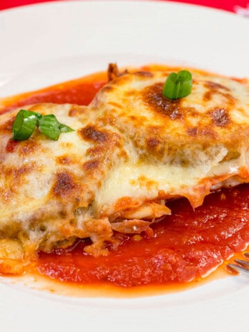 chicken topped with eggplant, melted cheese in tomato sauce