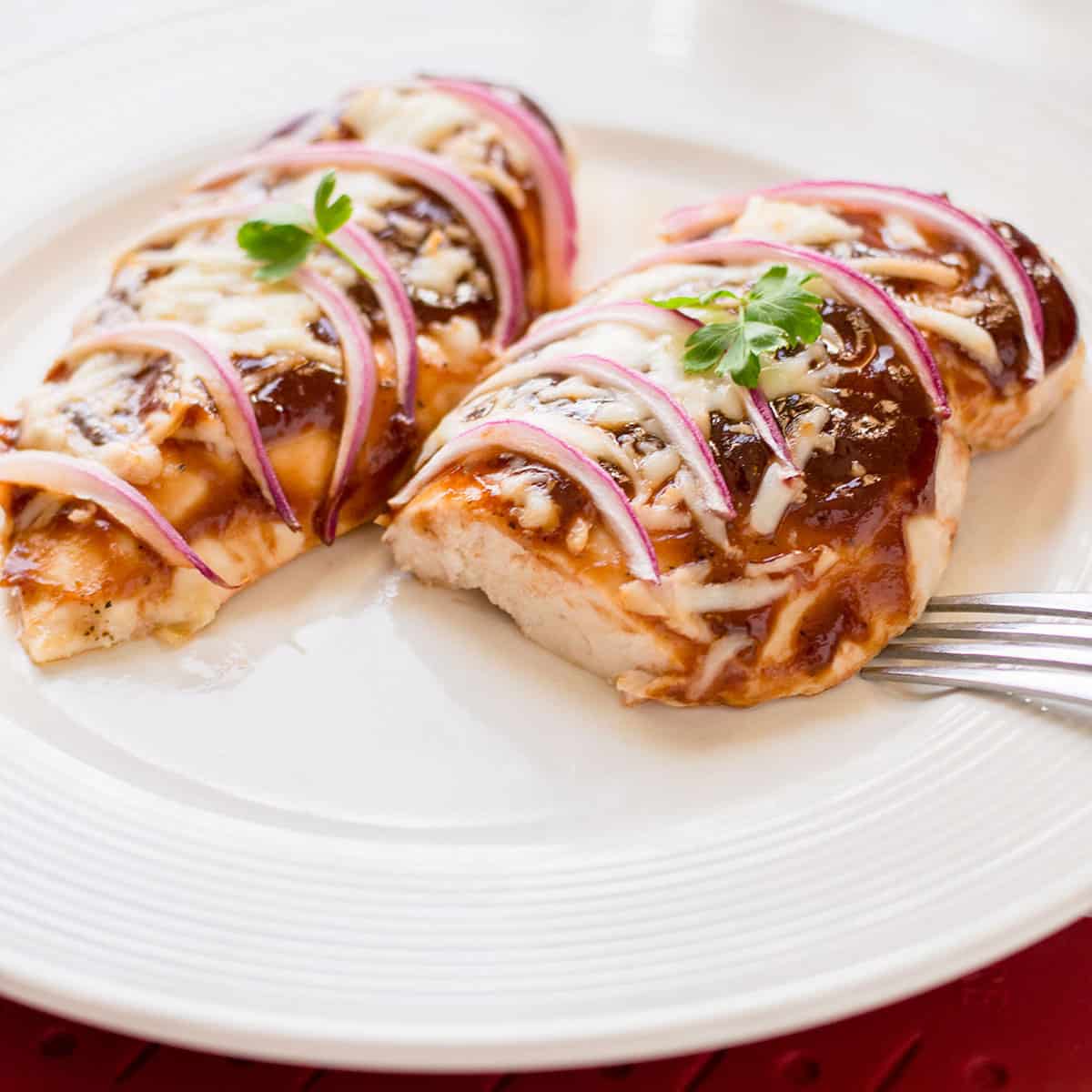 bbq chicken breasts with mozzarella and onions on plate