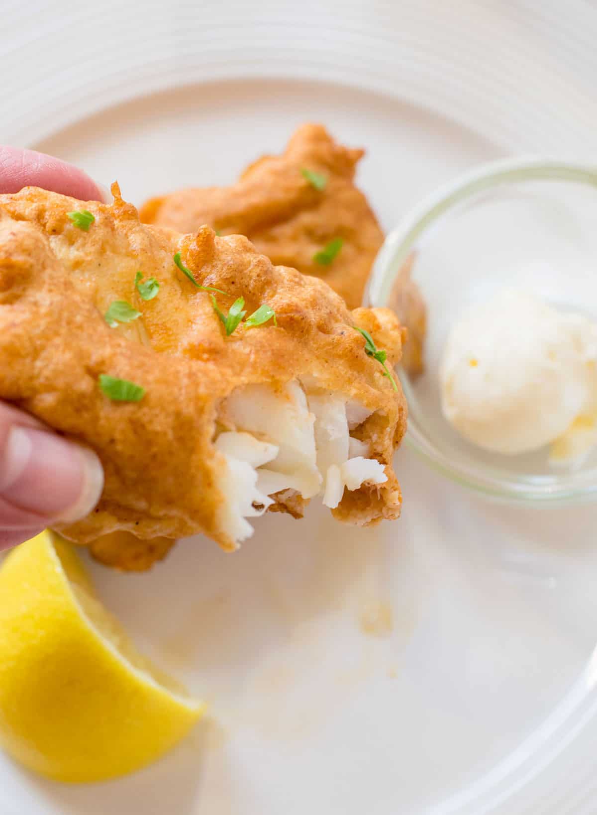 holding bitten piece of deep fried cod