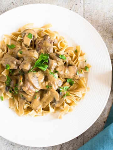 beef Stroganoff with mushrooms and noodles on plate