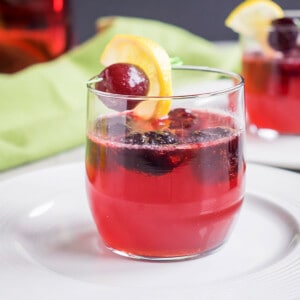 cherry cocktail with black cherry and lemon garnish