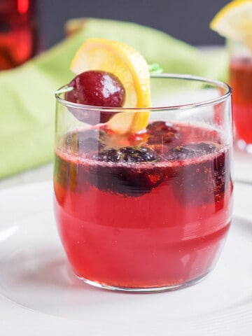 cherry cocktail with black cherry and lemon garnish