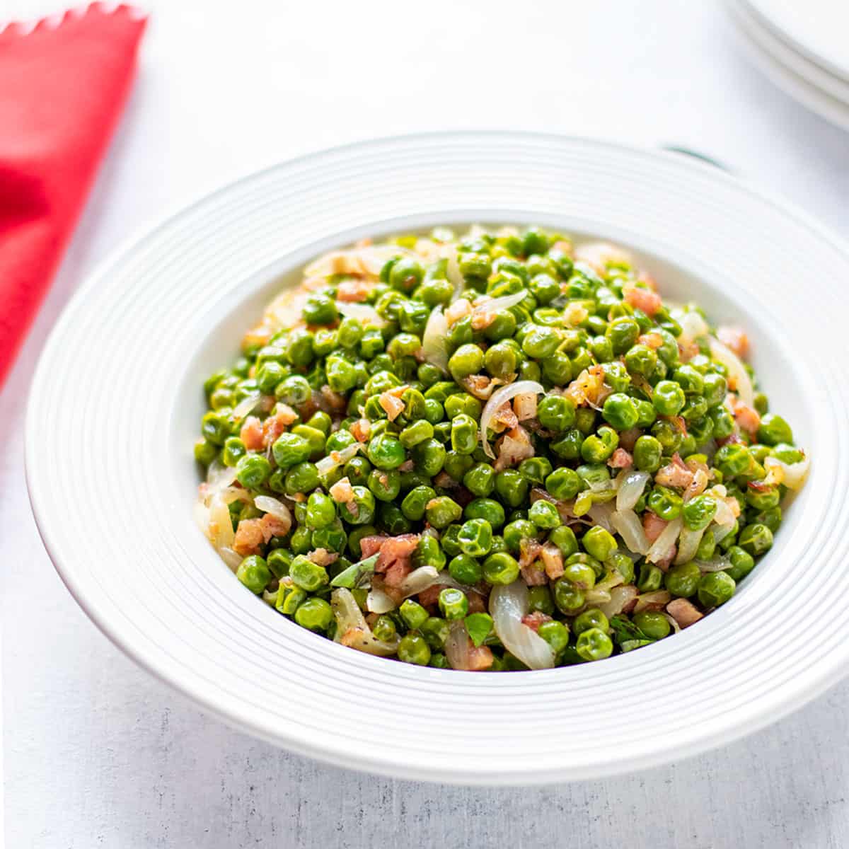bowl of peas with pancetta and onions
