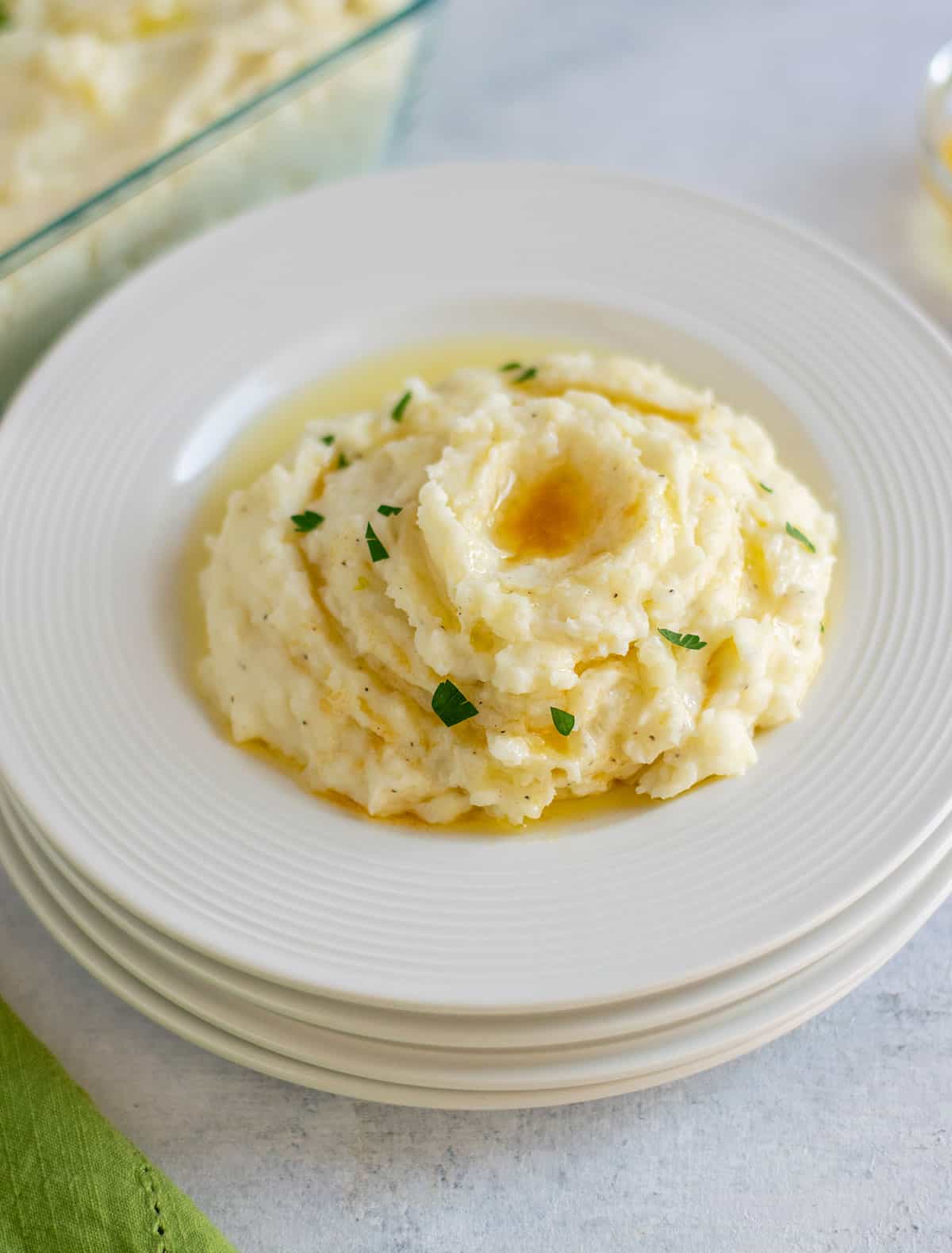 mashed potatoes with brown butter on stack of plates