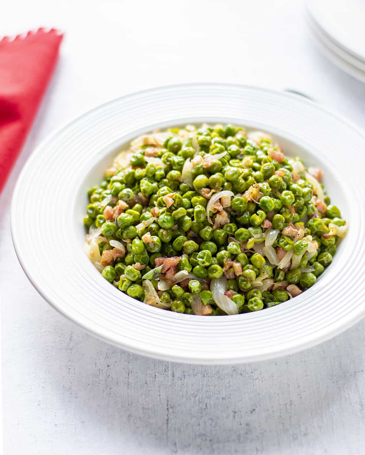 bowl of cooked peas with onions and pancetta