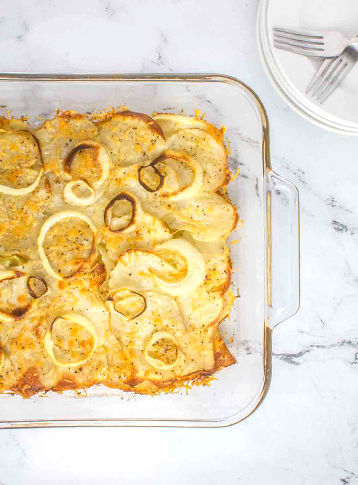 glass pan of cooked sliced potatoes with onions