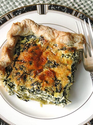 slice of spinach ricotta pie on plate with fork