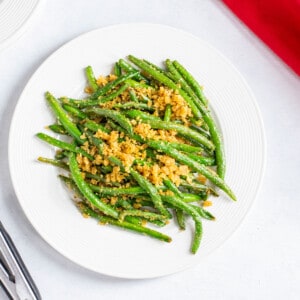 plate of cooked green beans with bread crumbs