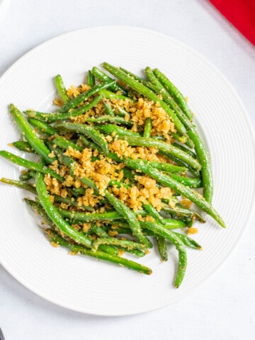plate of cooked green beans with bread crumbs