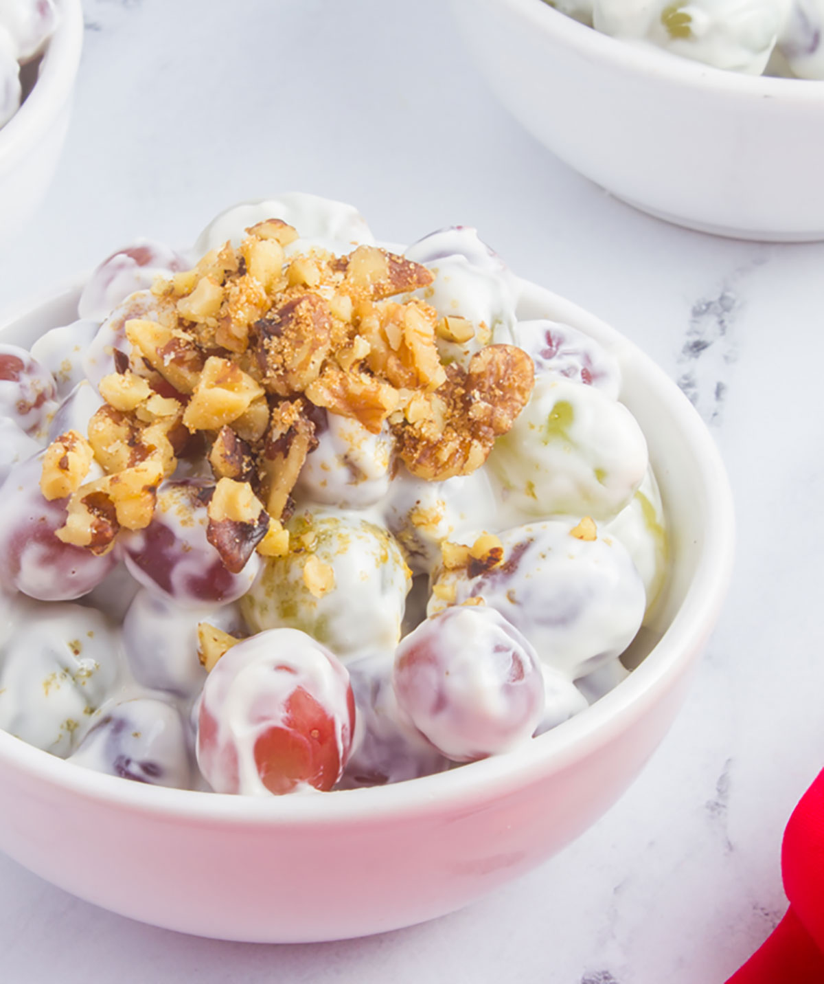 bowl of creamy grape salad with nut topping