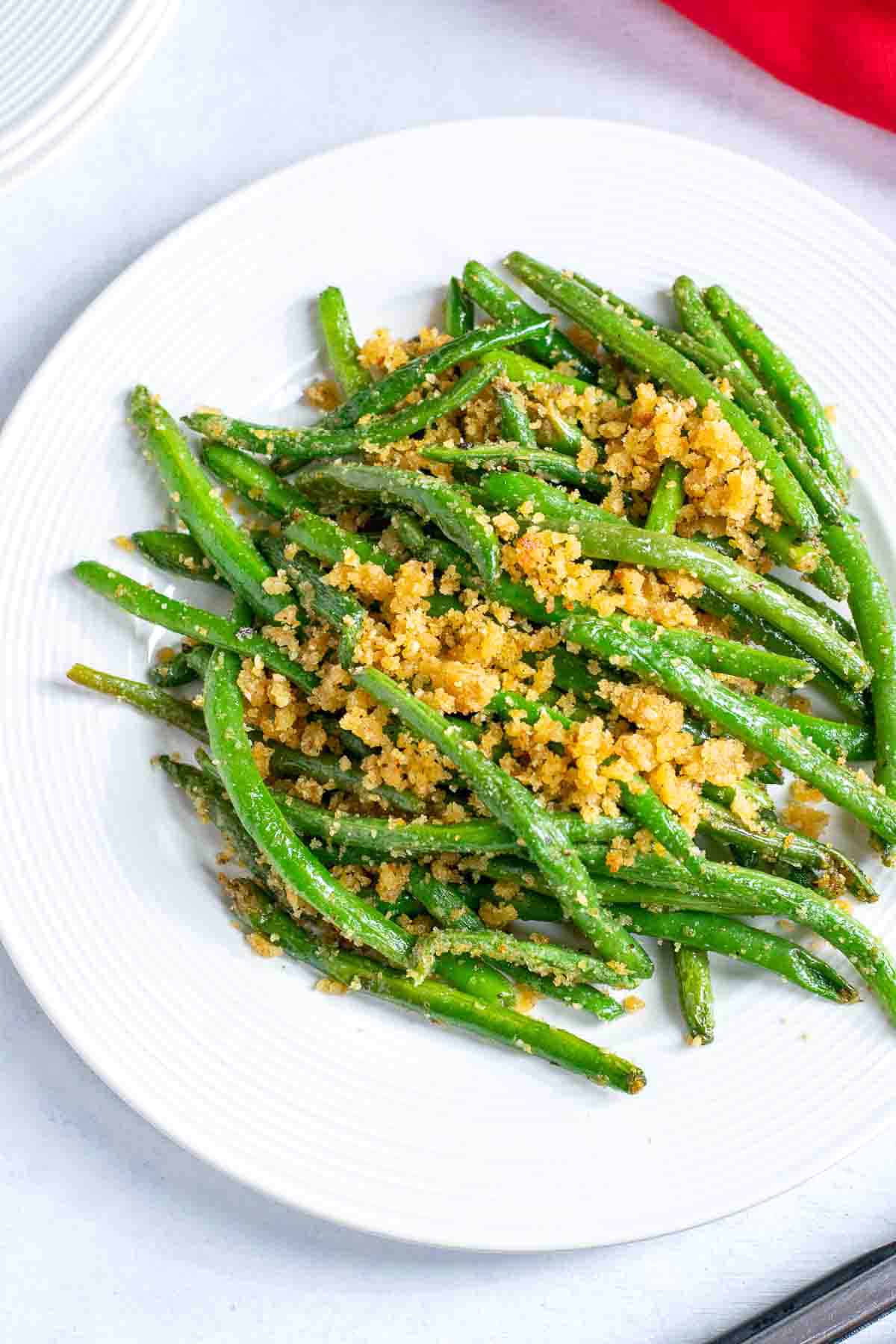 cooked green beans with bread crumbs on white plate