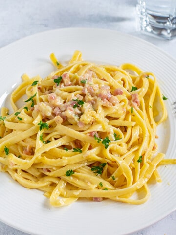 Fettuccine Carbonara on white plate with fork