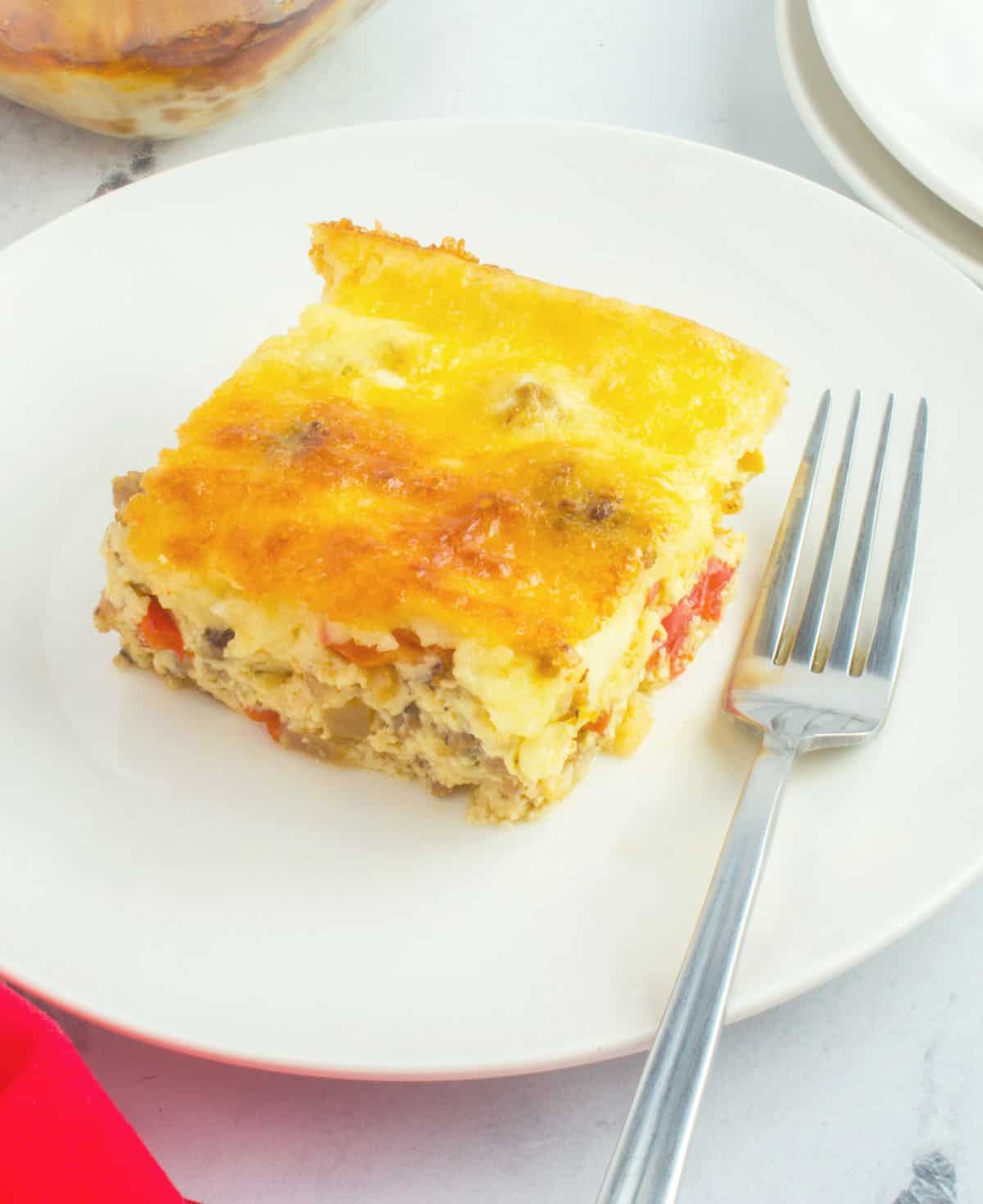 slice of egg casserole on plate with fork