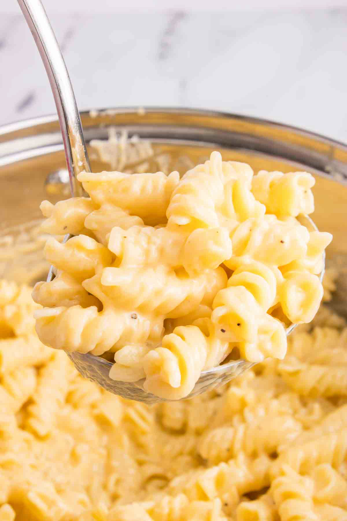 ladle of mac and cheese from pot