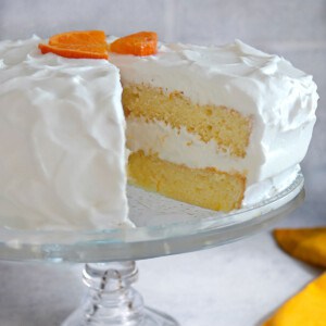 slice cut out of orange sponge cake with whipped cream