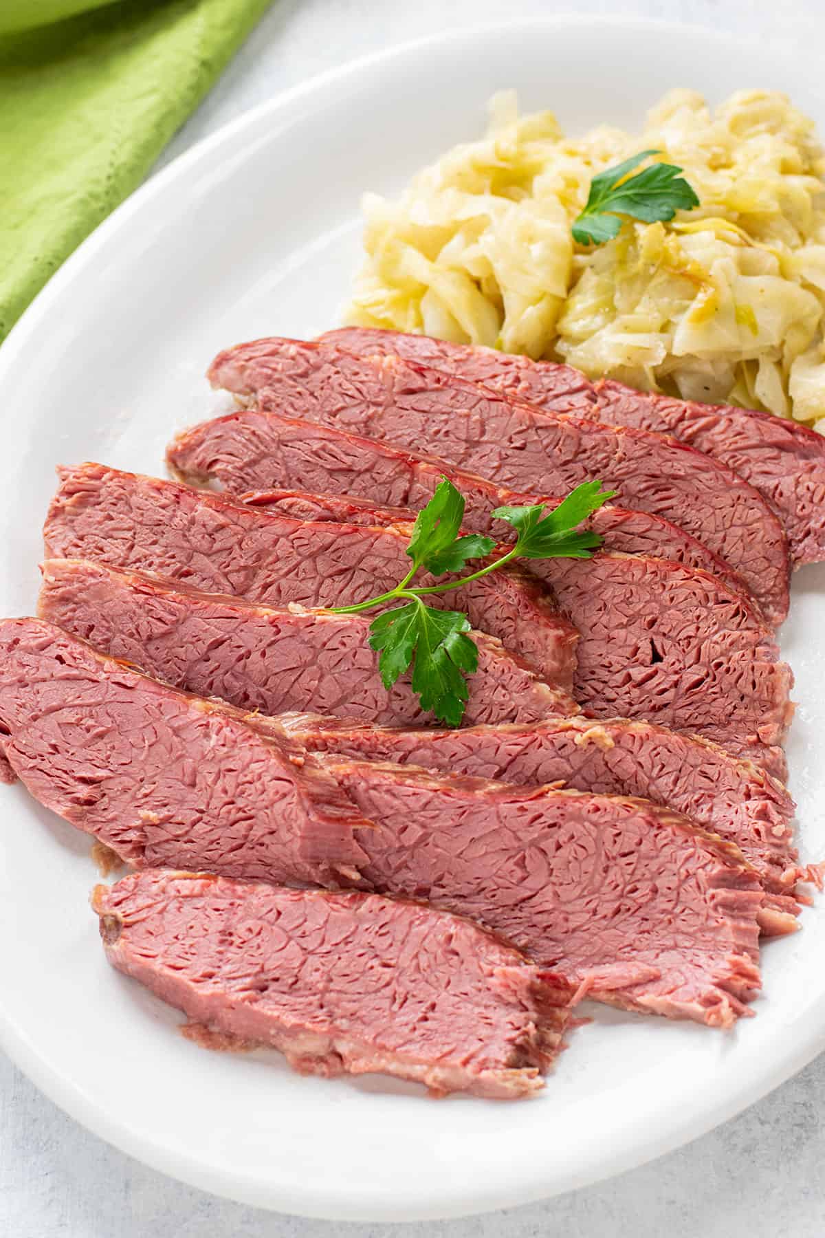 corned beef brisket sliced on a platter with sautéed cabbage