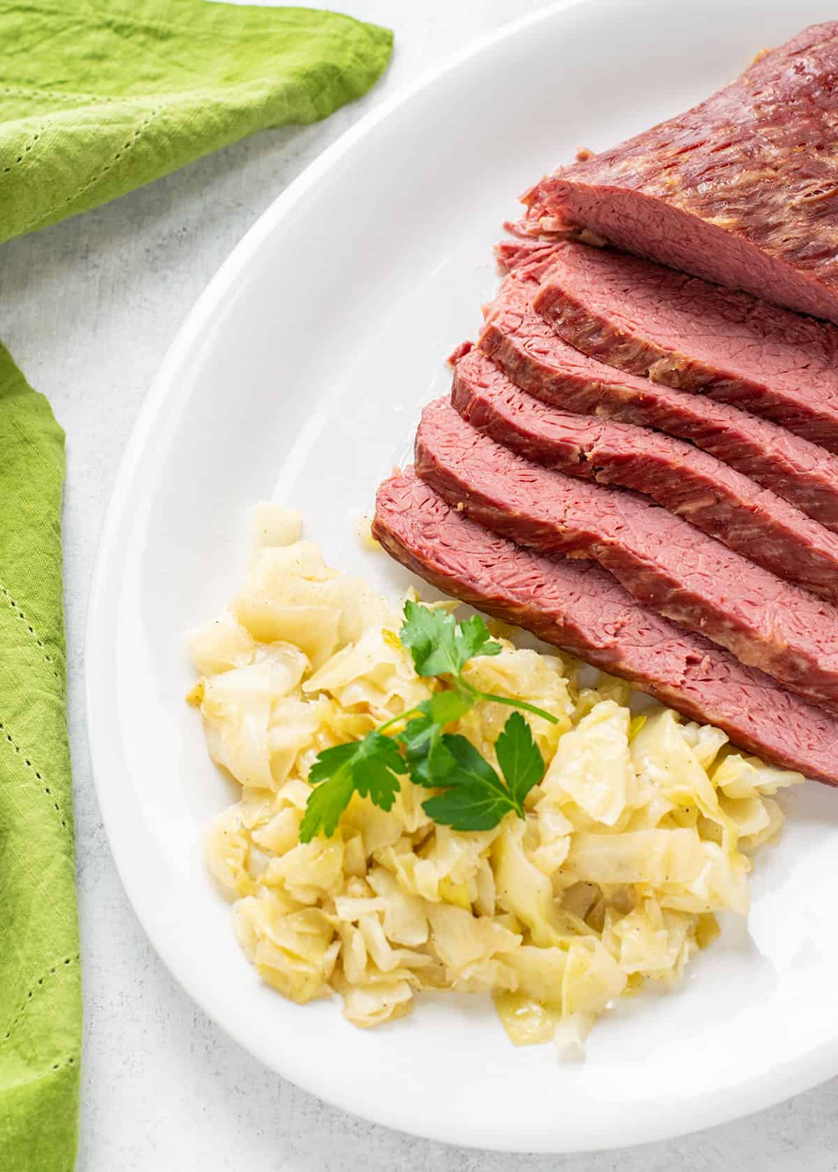 corned beef brisket sliced on a platter with sautéed cabbage