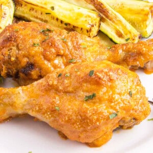 baked chicken drumsticks on plate with zucchini