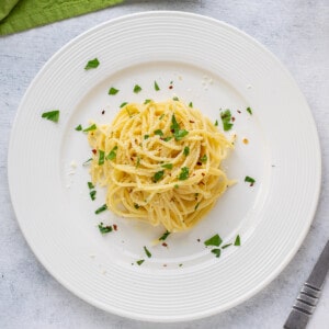cooked spaghetti in a plate with parsley.