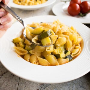 spoonful of prepared pasta with zucchini over a soup dish
