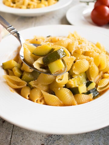spoonful of prepared pasta with zucchini over a soup dish