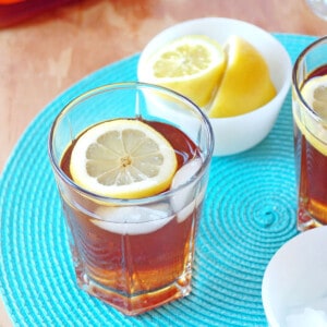 glass of rum and iced tea cocktail with lemon slice and ice cubes.