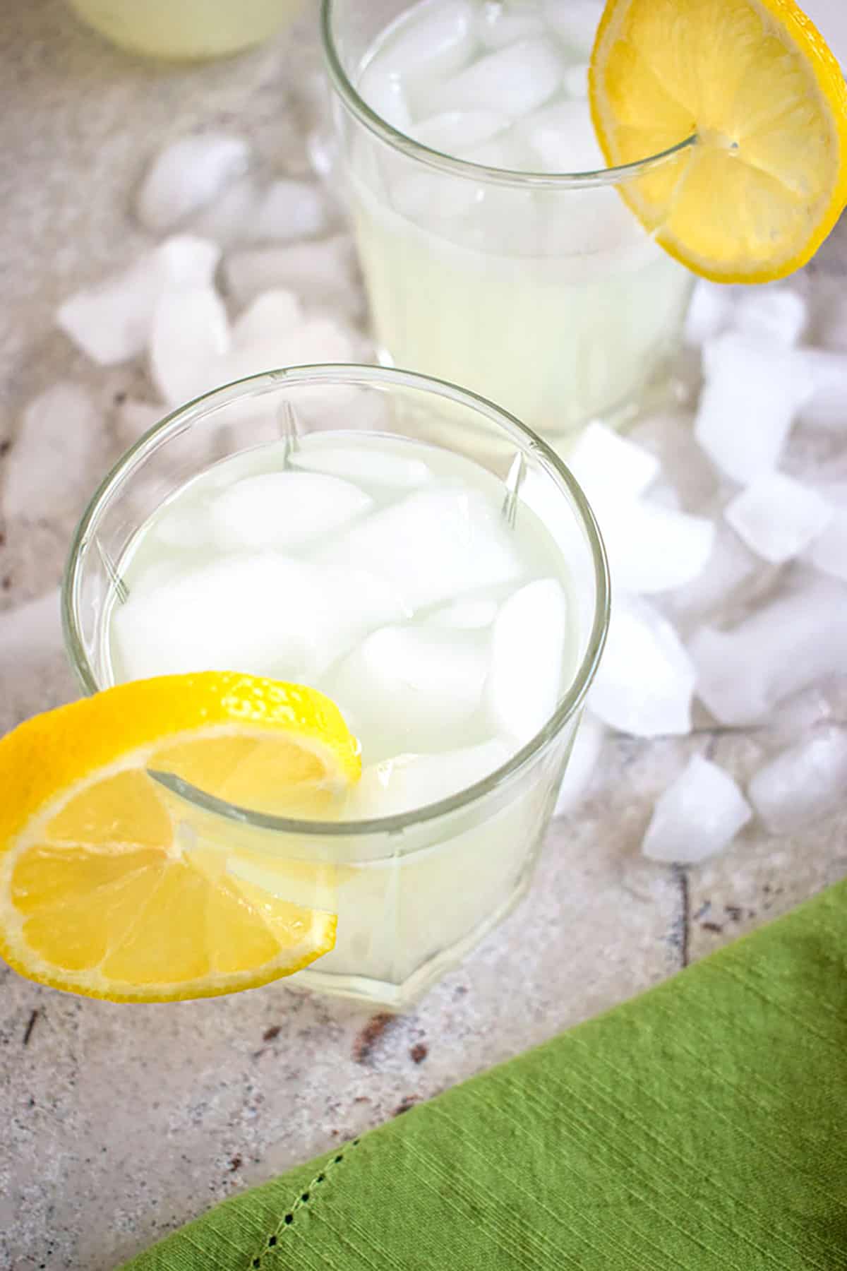 lemonade moonshine in a glass with a lemon slice surrounded by ice