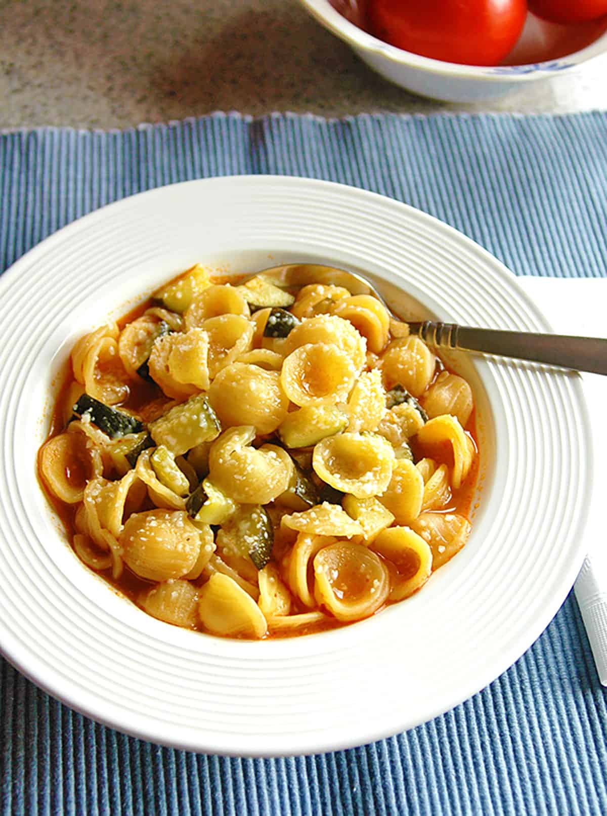 bowl of zucchini pasta with broth and spoon