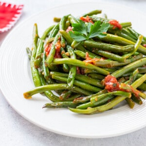 green beans with tomato sauce and parsley on plate