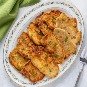 platter of breaded pork chops garnished with basil