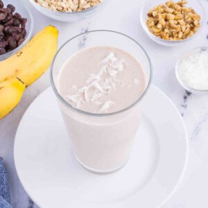 oatmeal smoothie in a glass garnished with coconut flakes
