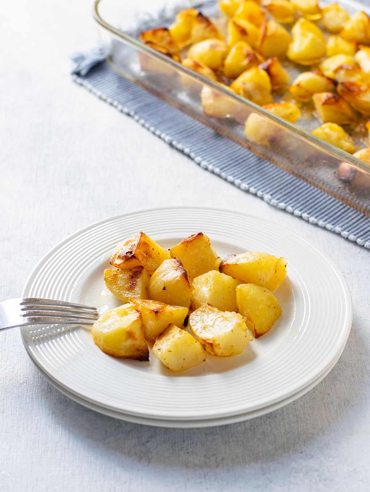 roasted potatoes on a plate with a fork