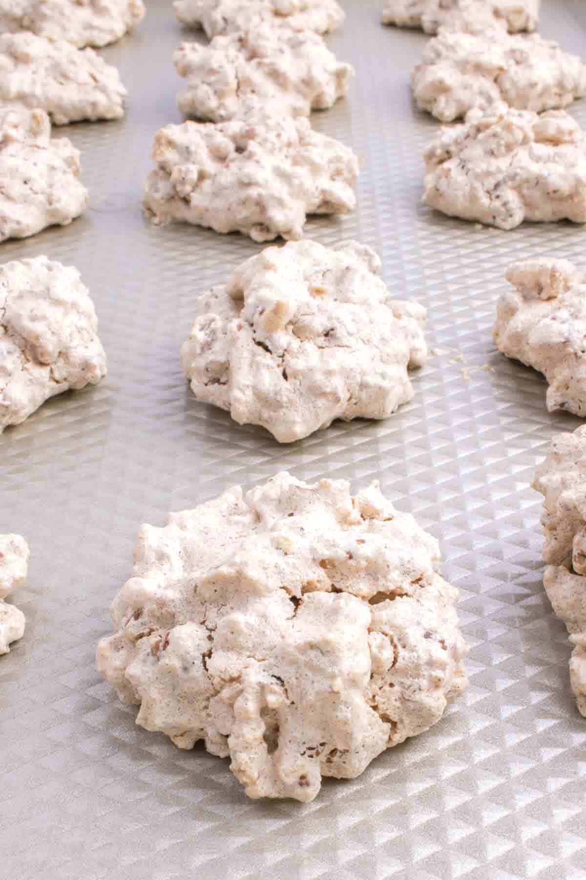 baked pecan meringue cookies on a baking sheet