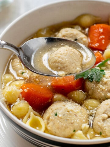 bowl of chicken meatball soup with a spoonful of soup