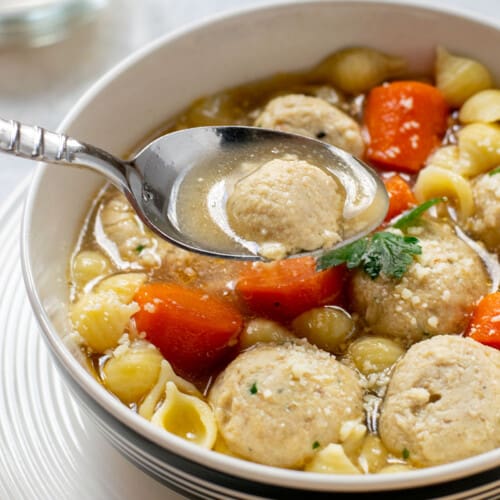 bowl of chicken meatball soup with a spoonful of soup