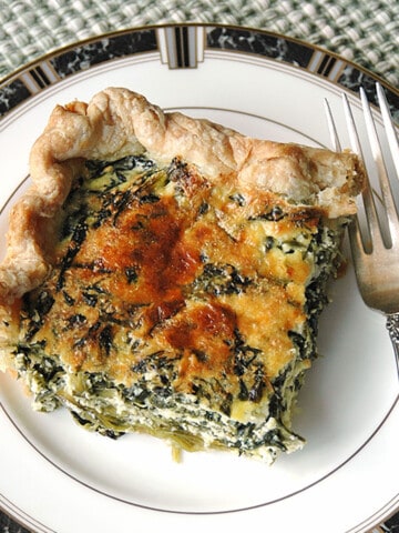 square piece of spinach ricotta pie on a plate with a fork