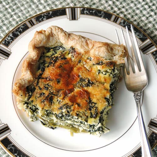square piece of spinach ricotta pie on a plate with a fork