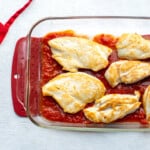 Browned thin chicken breasts in pan with tomato sauce