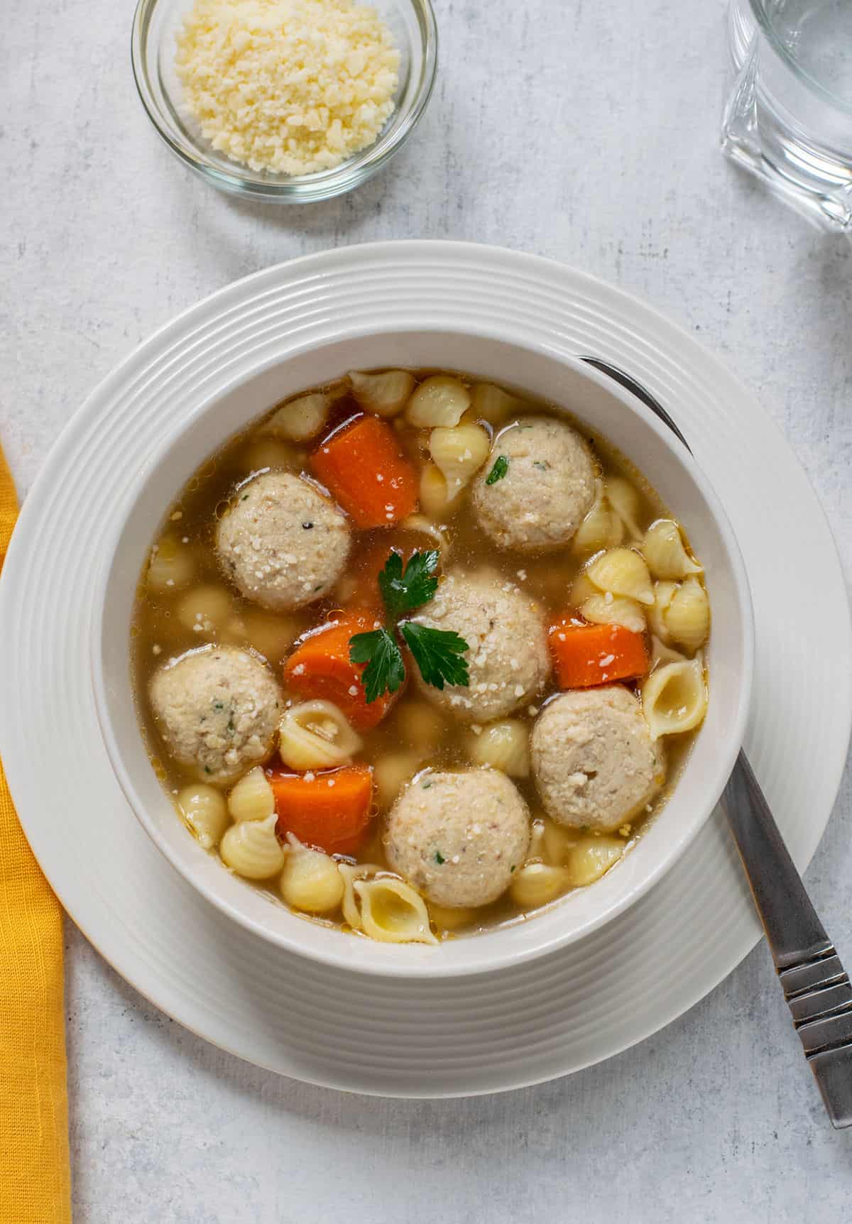 bowl of chicken meatball soup garnished with parsley