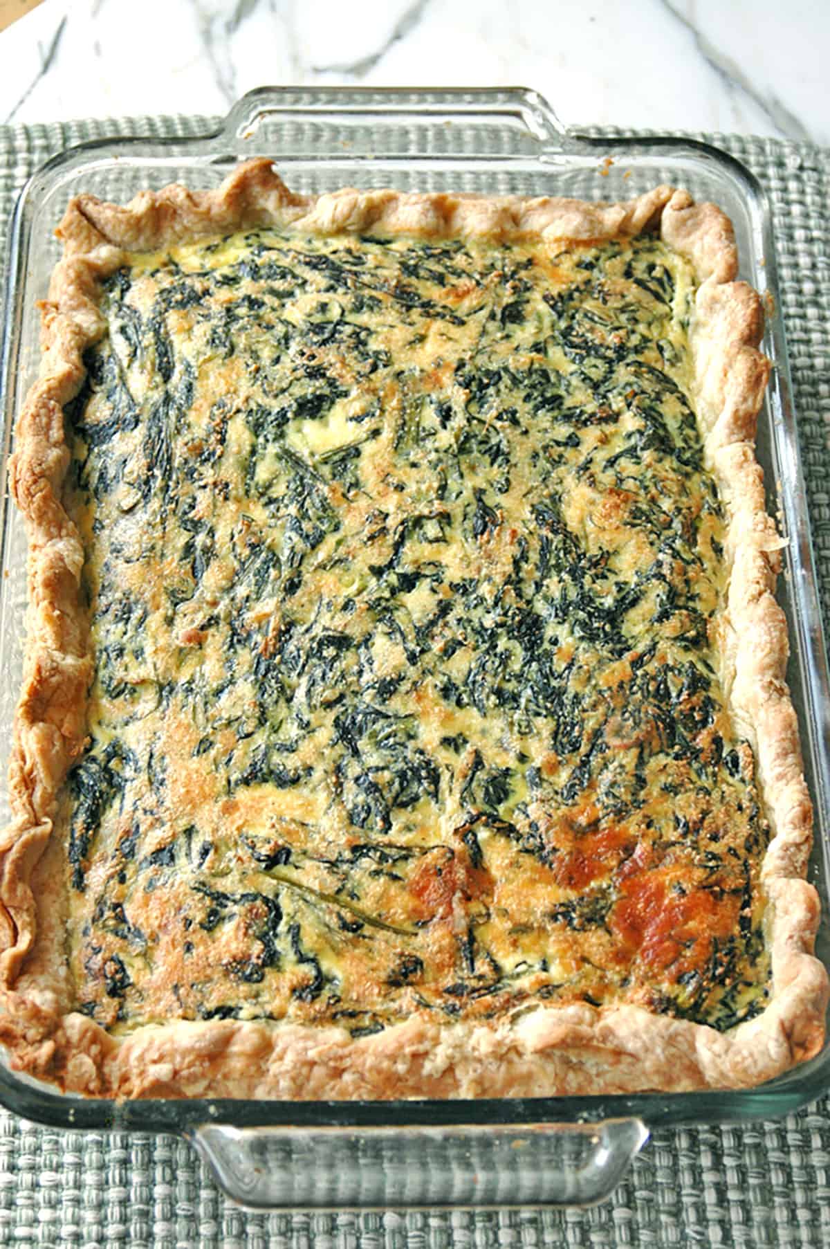 glass pan of baked spinach ricotta pie